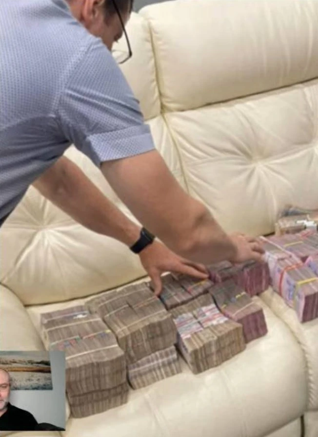 Людина, що схожа на Івана Баканова, ніби як перераховує готівку від Ваганяна